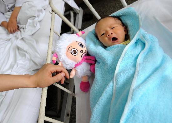 图文:护士在照看禹里乡刚出生10多天的婴儿