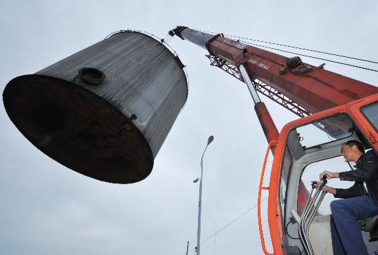 图文:一名司机操作吊车起吊巨型油罐
