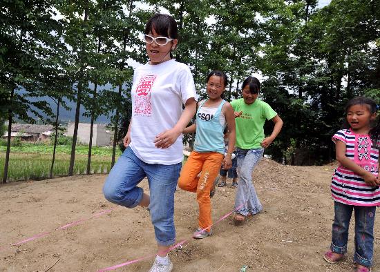 图文:志愿者与小学孩子一起玩跳皮筋