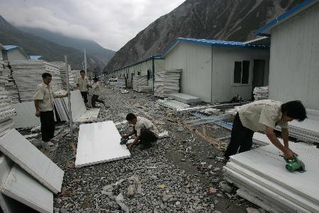 图文:工人在加紧安装活动板房