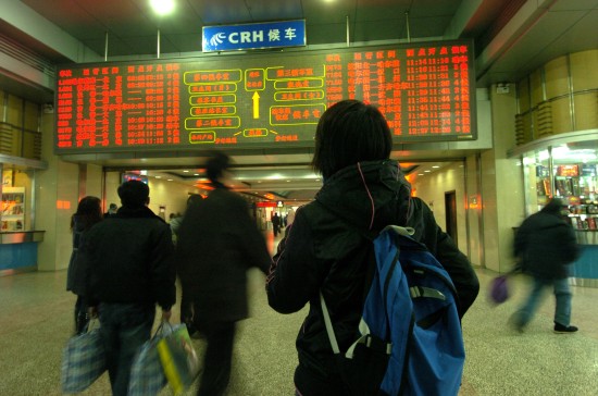 图文旅客在长春火车站候车大厅入口查看信息