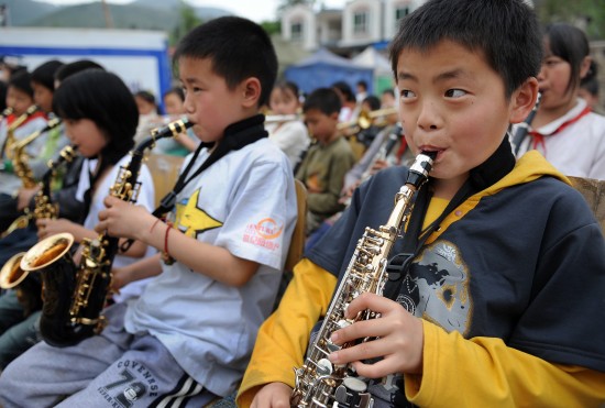 图文:徐广与学校管乐队的队员在校园里演奏