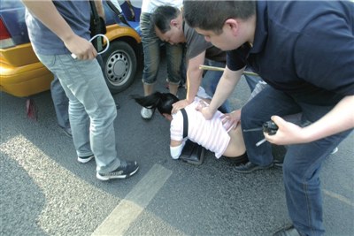 便衣民警在丽泽路路口抓捕一名女嫌疑人.图片来源:京华时报