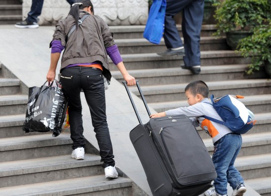 图文:广西南宁火车站小朋友帮母亲推行李