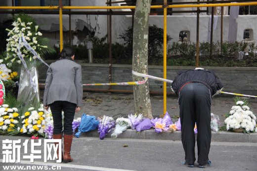 11月17日，两名市民在上海胶州路火灾现场进行哀悼。