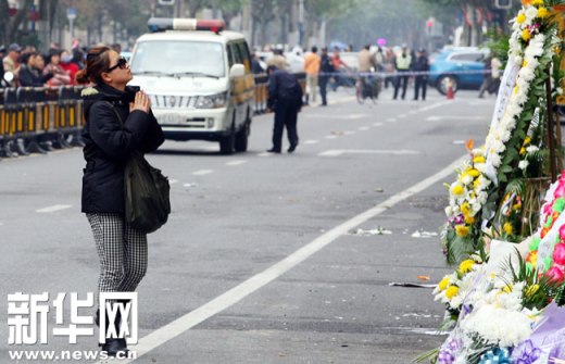11月17日，一名市民在上海胶州路火灾现场进行哀悼。新华社签约摄影师 范筱明 摄