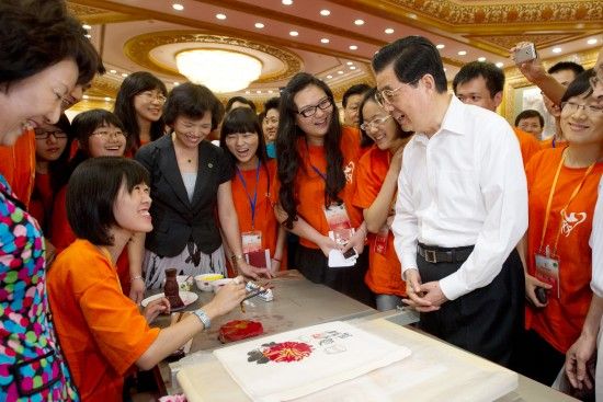 胡锦涛同正在尝试用木版水印技艺复制国画作品的台湾青年亲切交谈。新华社记者 李学仁 摄