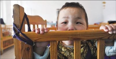 大部分婴儿床"遍体鳞伤,为了防止床晃动不稳,福利院的阿姨用绳子将床