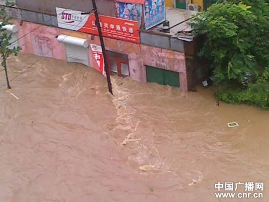 8月4日，秦皇岛市海港区内涝严重，当地正在用铲车清理积水（刘磊摄） 
