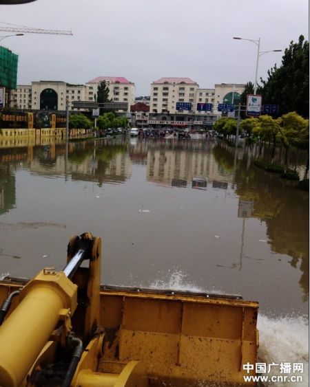 8月4日，秦皇岛市海港区内涝严重，当地用铲车清理积水（刘磊摄）
