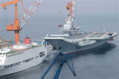 4月20日，辽宁舰重返大连停泊在造船厂泊位，工作人员正在从港区和甲板上吊装物品，工作船也在水中维护。4月17日晨，辽宁舰返回了大连港。据悉，此次其重返大连或将进行中期维护保养。图/CFP