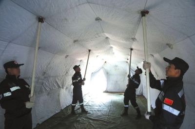 搭建帐篷。在演练现场,大众卫生救援队员选取平地,铺上塑料地垫后将网架式帐篷快速散开。据介绍,这顶面积37㎡的帐篷在很多灾区被广泛应用,可用于医疗、通讯、住宿等。针对灾区可能存在的蚊虫较多的情况,帐篷还有地垫可直接连接侧壁等设计。 搭建帐篷。在演练现场,大众卫生救援队员选取平地,铺上塑料地垫后将网架式帐篷快速散开。据介绍,这顶面积37㎡的帐篷在很多灾区被广泛应用,可用于医疗、通讯、住宿等。针对灾区可能存在的蚊虫较多的情况,帐篷还有地垫可直接连接侧壁等设计。