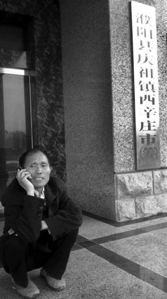 5月12日，李连成在“西辛庄市”的牌子旁边安排工作。本报记者 周亦楣 摄