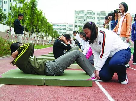 在新华中学体育课上,女生在练习体育中考必考科目仰卧起坐(资料片)