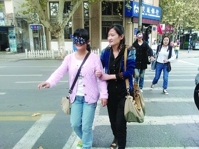 志愿者蒙眼体验盲人过马路