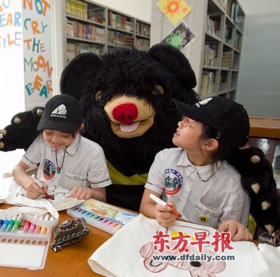 小学生和黑熊玩偶合影