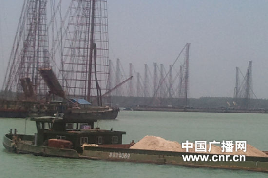 拉沙船从数量众多的采砂船旁经过。 拉沙船从数量众多的采砂船旁经过。