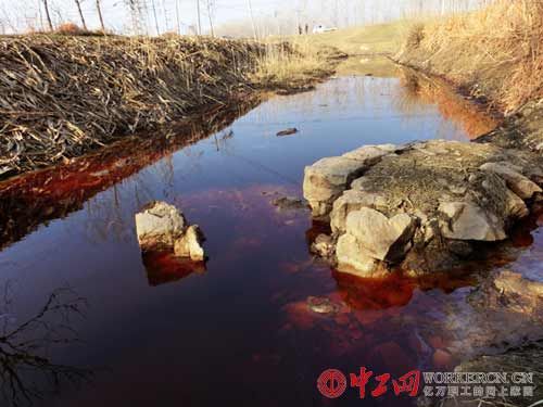 当天下午，记者看到唐店化工园区红色污水横流，浸满周边农田沟渠；当地投诉人称这些红污水通过暗管和明渠排入