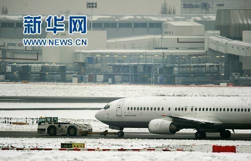 12月21日，在英国伦敦希思罗机场，一架飞机被拖车从停机坪上拖过。新华社/法新