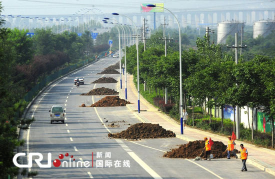 2011年7月18日，西安市东三环穆将王立交桥南侧约一公里长的辅道上，18日凌晨被倒了12堆土，间隔50米至100米不等。图片来源：CFP 