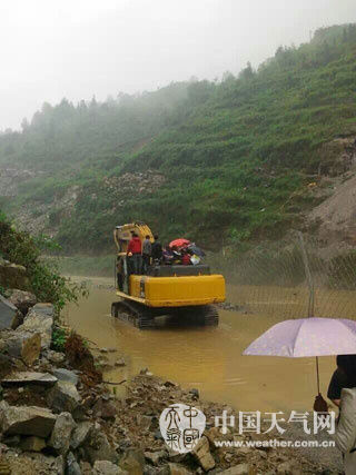 6月3日，遵义务川县一条临时公路被淹，挖掘机载人“过河”。