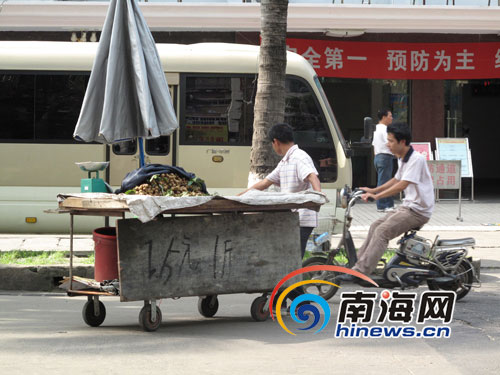 水果贩正在推车到马路边卖水果(南海网记者 陈望摄)