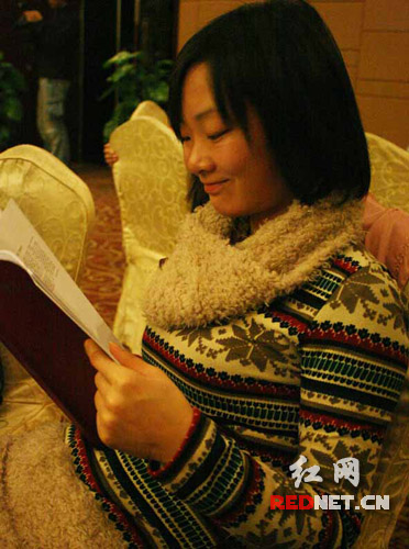 (衡阳通讯员何青青在答谢会上高兴地阅读《潇湘晨报》通讯员优秀