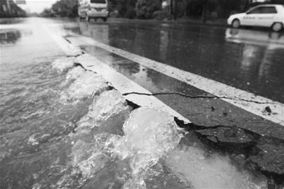 图文汹涌雨水撑破沥青路面