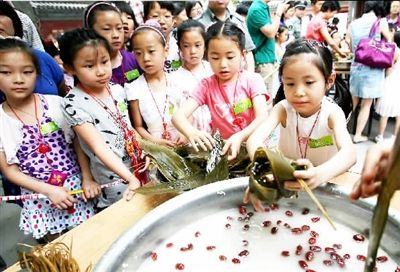 小学生们 饶有兴致 地参加包粽子比赛