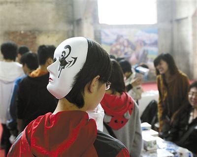 10月22日,2011北京国际动漫周上,一女孩将面具戴在头后,好似一个