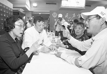 医师在专业手语翻译的协助下与聋人患者沟通,