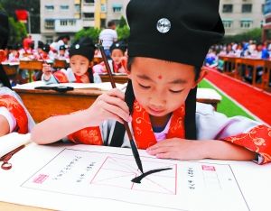 七里河小学480余名新生集体举行"开笔礼"; 孩子们描红"人"字开笔