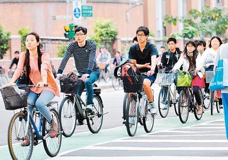 图为台湾大学学生骑车离开校园.图自《中国时报》