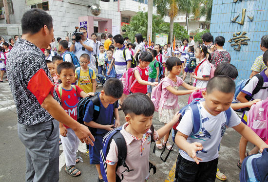 家长校门口做义工 疏导交通带娃过路
