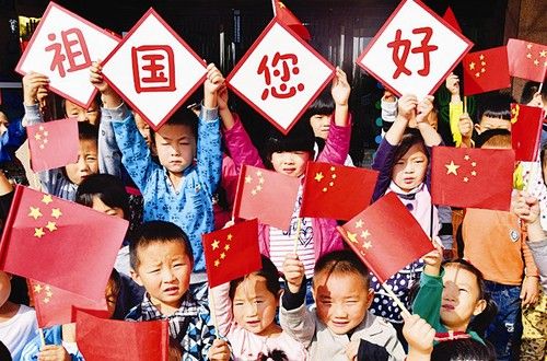 垣曲县城南幼儿园的孩子挥动国旗向祖国问好