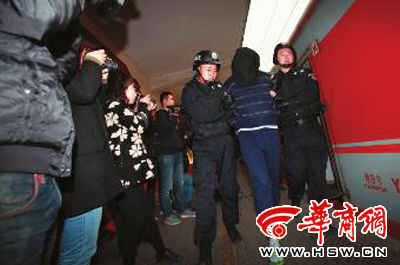 昨日,西安火车站,5名犯罪嫌疑人被警方从海南押解回西安 本报记者