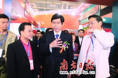 茶山镇镇长黄少峰(左)向国家商务部党组成员房爱卿(中,广东省经信委