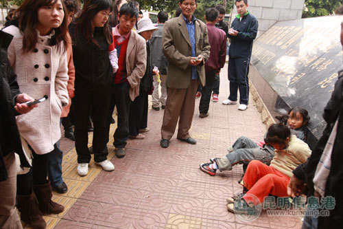 女孩被绑，引来很多市民围观。记者朱仁严/摄