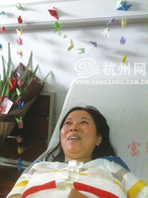 看到同事送来的千纸鹤，吴菊萍开心地笑了。记者 张姝 摄