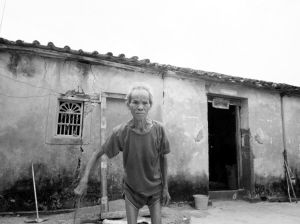 由于新房子小，不够住，郭吉侬90多岁的父亲还住在身后的危房里