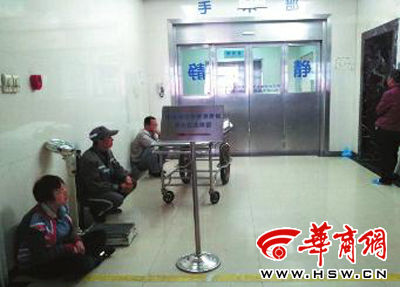 手术室外，年轻的母亲小丽（化名）坐在地上泪流满面 本报记者 汤继颖 摄 