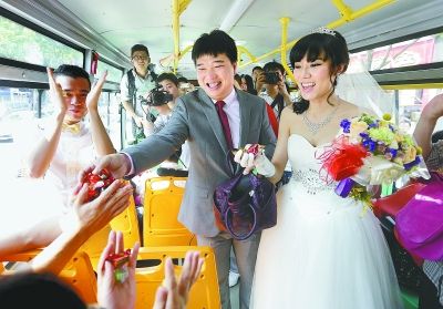 一对新人乘公交车结婚,并向车上乘客发喜糖.记者王翮 摄