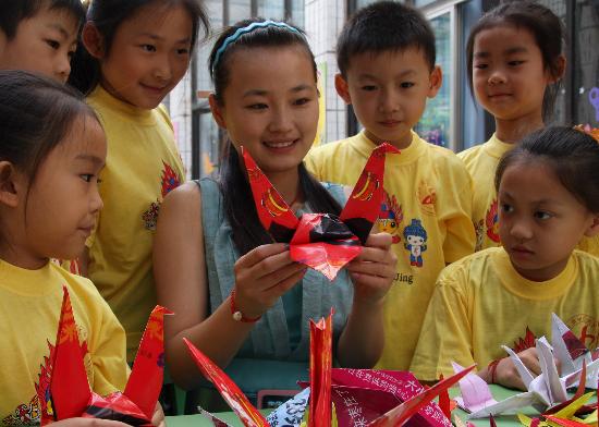 图文:幼儿园老师指导孩子们折叠千纸鹤