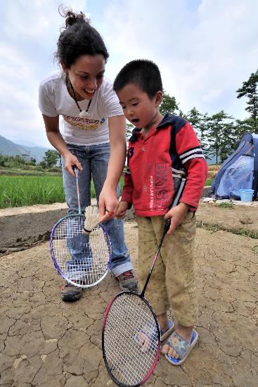 图文:志愿者指导晓坝镇中心小学孩子打羽毛球