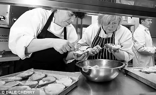 厨师长乔・米勒和她的伙伴工作时需要俯下身子，贴近看手里的活儿。