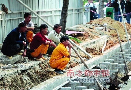 昨日，两名工人身亡后，工友蹲在事发坑道边一脸茫然。南都记者 王子荣 摄