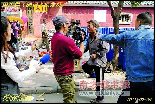 正在行乞的老人拿起凳子砸向记者手中的摄像机。受访者供图