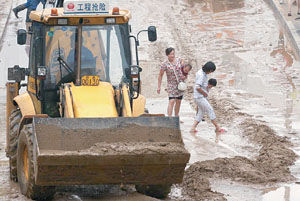 抢修车辆正在清理路面淤泥。 摄/记者 林晖（图片来源：法制晚报）