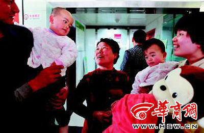 昨日，奶奶陈女士（中）看到抱出ICU病房的双胞胎孙女很开心。本报记者 张杰 摄