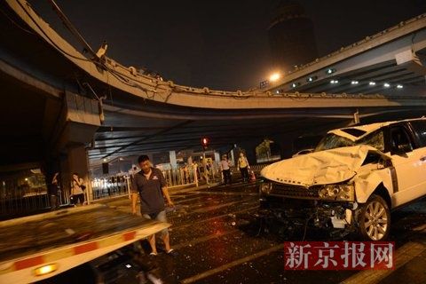 凌晨1点半,撞断护栏坠落的路虎车被拖车拉走。新京报记者 王子诚 摄 凌晨1点半,撞断护栏坠落的路虎车被拖车拉走。新京报记者 王子诚 摄